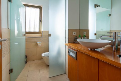 Warme Fliesen, Milchglas, Holz und Tageslicht: eine gelungene Symbiose für jedes elegante Büro-WC.