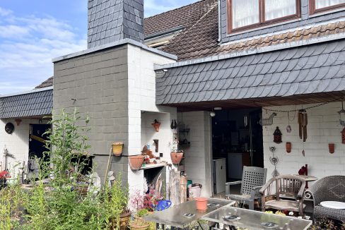 Rückseite mit Terrasse und Kamin