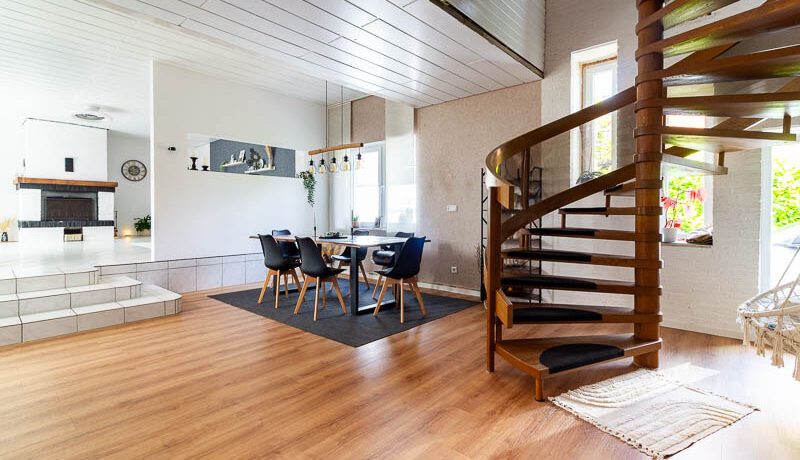 Offene Grundrissgestaltung mit Blick zur Küche und eleganter Holztreppe – ein echtes Wohnhighlight.