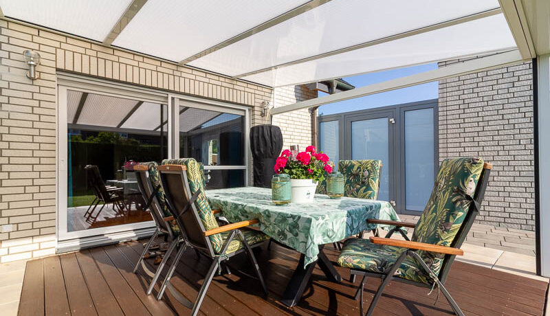 Die Terrasse, überdacht und mit direktem Zugang zum Garten – der perfekte Ort für entspannte Stunden im Freien.