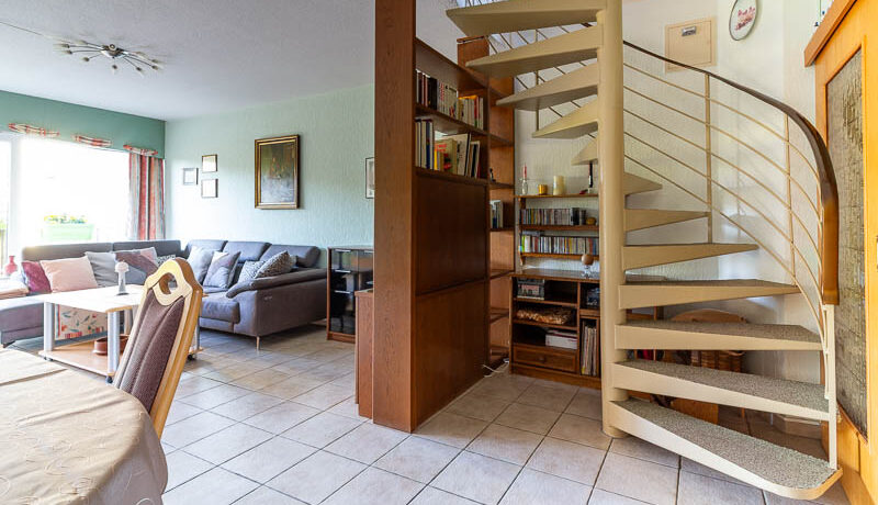 Elegante Wendeltreppe, die das offene Raumkonzept perfekt ergänzt und den Zugang zum Obergeschoss ermöglicht.