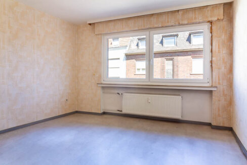 Helles Schlafzimmer mit großem Fenster – viel Potenzial für einen gemütlichen Rückzugsort.