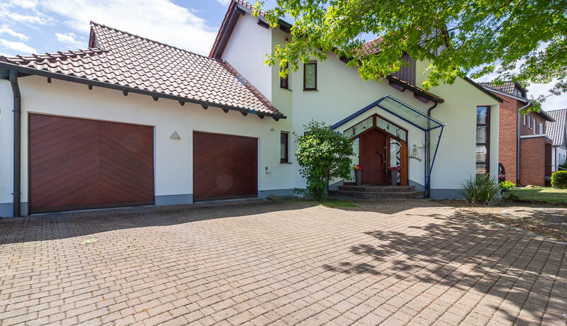 Großzügige Einfahrt, zwei Garagen und ein einladender Hauseingang – dieses Zuhause überzeugt schon beim ersten Eindruck.