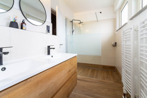 Modern, hell und komplett kernsaniert – das Badezimmer überzeugt mit begehbarer Dusche, Doppelwaschbecken und hochwertiger Ausstattung.