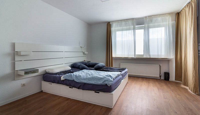 Ruhiges Schlafzimmer mit modernisierten Details und Balkonzugang.
