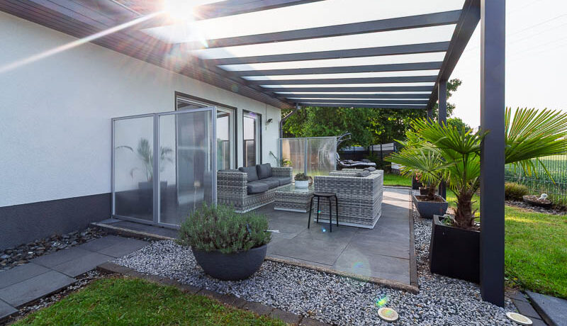 Stilvoller Outdoorbereich mit Glasüberdachung – ein Ort für gesellige Abende und ruhige Momente.