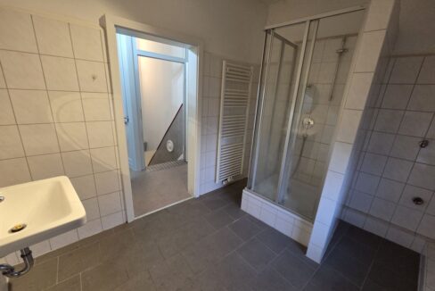 Badezimmer mit Sicht auf Dusche und Flur im OG
