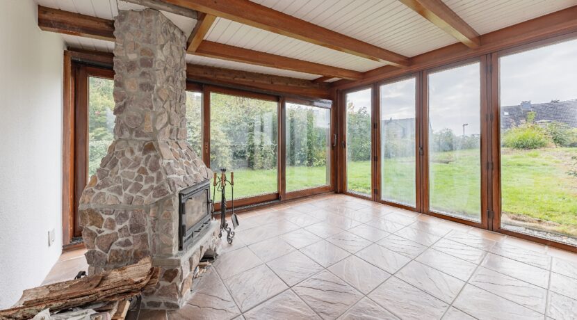 Wintergarten mit grüner Aussicht und Kamin