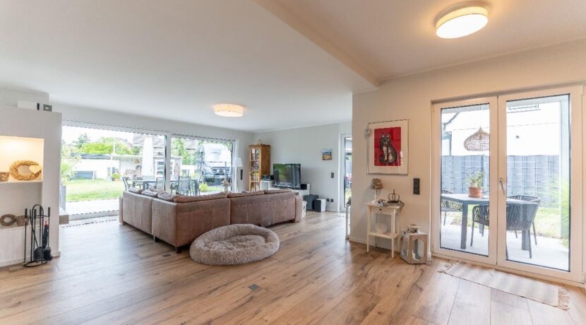 Lichtdurchfluteter Wohnbereich mit Kamin und diversen Zugängen zum liebevoll ang