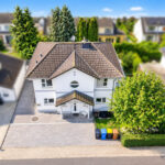 Sonniger Vorort mit weißem Traumhaus